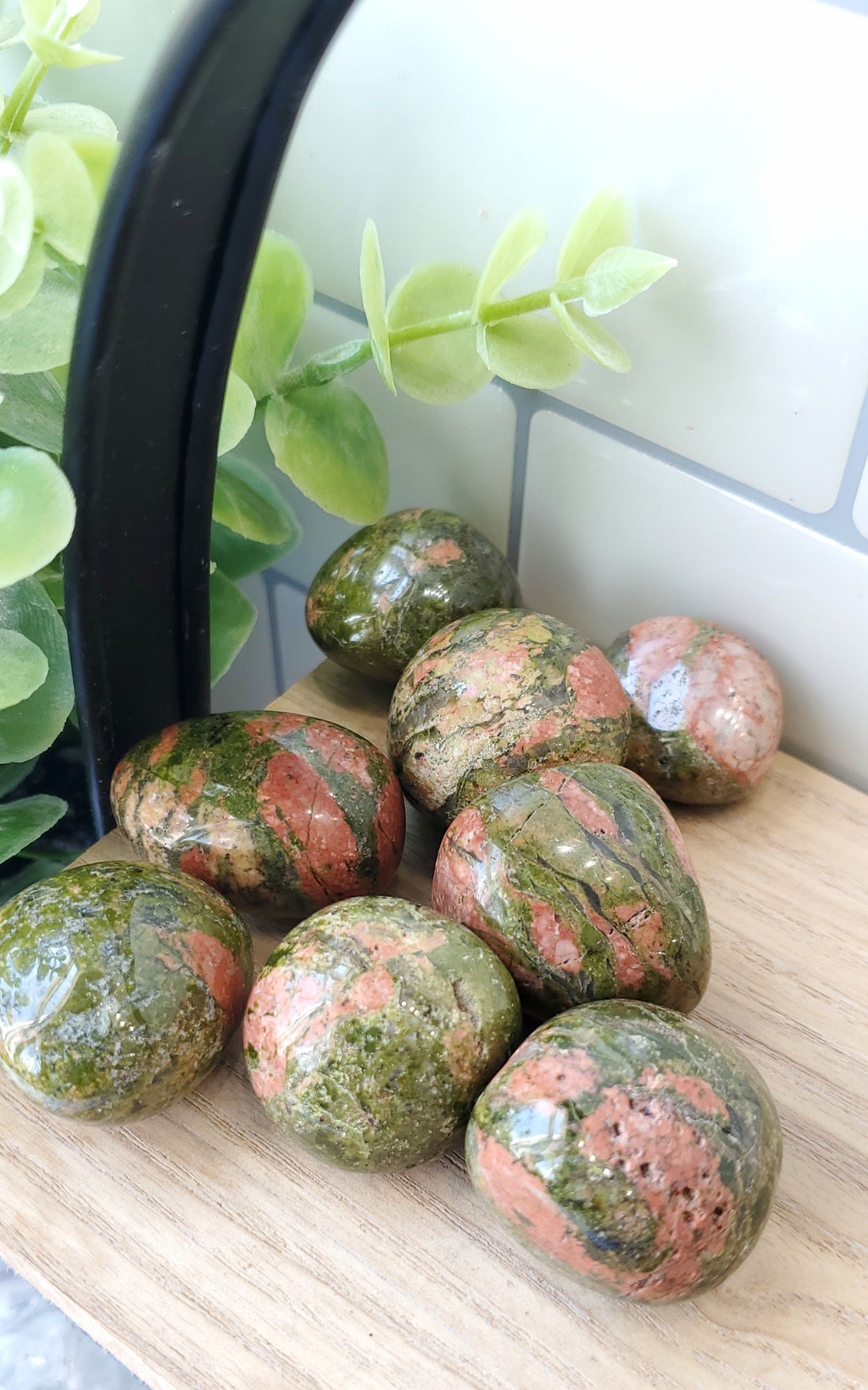 Unakite crystals stones piled on a wooden shelf